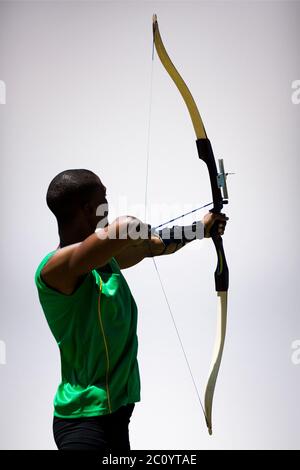 Zusammengesetztes Bild der Rückansicht der Sportler tun Bogenschießen auf weißem Hintergrund Stockfoto