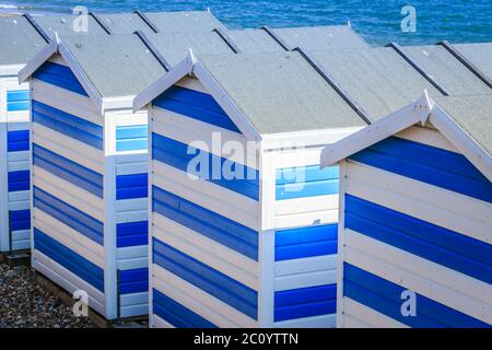 Blau-weiße Strandhütten am Meer in Hasting's UK, auf dem Ärmelkanal. Stockfoto