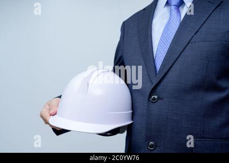 Geschäftsmann in der Hand hält eine weiße Plastikkappe Stockfoto