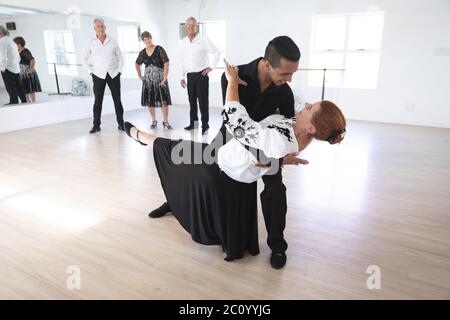 Mixed Race Tanzlehrer hilft seinem Ballsaal Tanzkurs Stockfoto