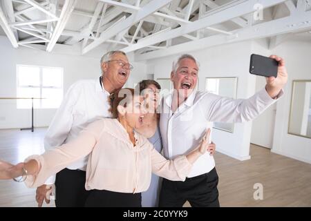 Glückliche kaukasische ältere Paare, die Selfies während des Tanzes im Ballsaal machen Stockfoto