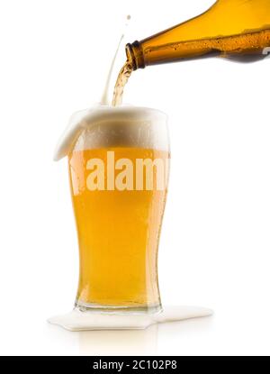 Blondes Bier mit Spritzschaum in Glas gießen, auf weißem Hintergrund Stockfoto