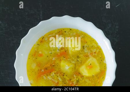 Gelbe vegetarische Suppe Draufsicht auf schwarzem Hintergrund Stockfoto