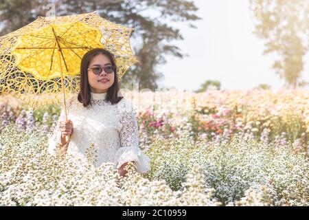 Portrait Bild einer asiatischen Frau mit Regenschirm in einem schönen weißen Cutter Blumengarten halten. Stockfoto