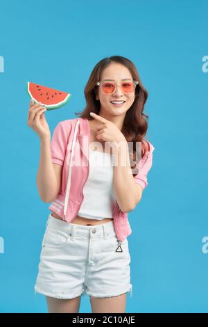 Gesunde asiatische junge Frau essen Wassermelone, Stockfoto