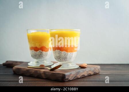 Hausgemachter Chia-Samenpudding mit Mango und Mandel im Glas auf Holzgrund Stockfoto