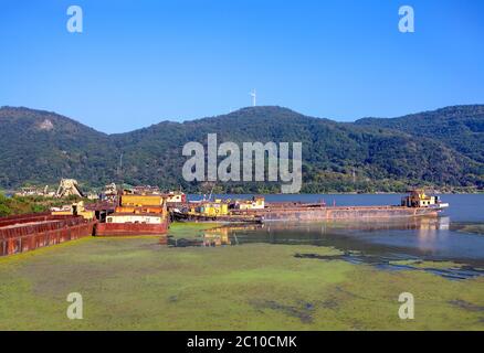 Flusshafen mit Ladetanker, Donau Flusslandschaft mit Industrieschiff Stockfoto