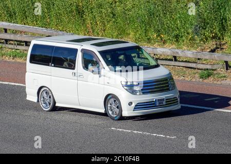 2002 weiße Nissan People Carrier; Fahrzeug Verkehr Fahrzeuge, Autos fahren Fahrzeug auf britischen Straßen, Motoren, Fahren auf der Autobahn M6 Stockfoto