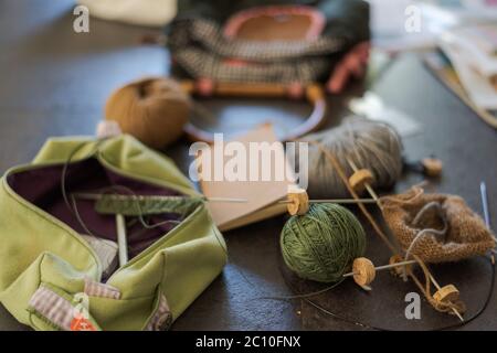 Chaotisch kreatives Chaos auf dem Tisch beim Stricken von Socken Stockfoto