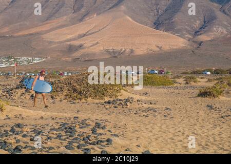 Famara Beach, beliebter Surfstrand an der Küste von Lanzarote. Kanarische Inseln. Spanien. Sanddünen und Menschen am Strand Stockfoto