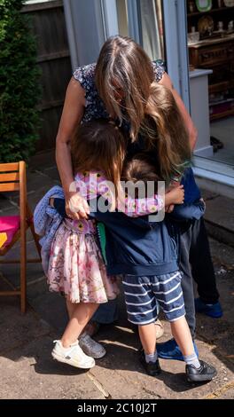 Susan hat sich nach der Einführung von Maßnahmen zur Lockdown-Lockout in England erstmals mit ihren Enkeln Emily (rechts), Benjamin (Mitte) und Daisy (links) in Ashtead, Surrey, wiedervereinigt, da allein in England lebende Menschen ab Samstag Stützblasen mit anderen Haushalten bilden können, Ende Wochen der Isolation unter Lockdown. Stockfoto