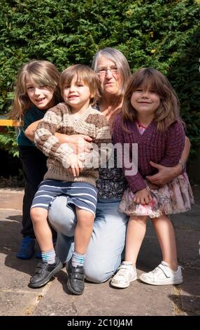 Susan hat sich nach der Einführung von Maßnahmen zur Lockdown-Lockout in England erstmals mit ihren Enkeln Emily (links), Benjamin (links) und Daisy (rechts) in Ashtead, Surrey, wiedervereinigt, da allein in England lebende Menschen ab Samstag Stützblasen mit anderen Haushalten bilden können, Ende Wochen der Isolation unter Lockdown. Stockfoto