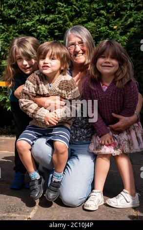 Susan hat sich nach der Einführung von Maßnahmen zur Lockdown-Lockout in England erstmals mit ihren Enkeln Emily (links), Benjamin (links) und Daisy (rechts) in Ashtead, Surrey, wiedervereinigt, da allein in England lebende Menschen ab Samstag Stützblasen mit anderen Haushalten bilden können, Ende Wochen der Isolation unter Lockdown. Stockfoto