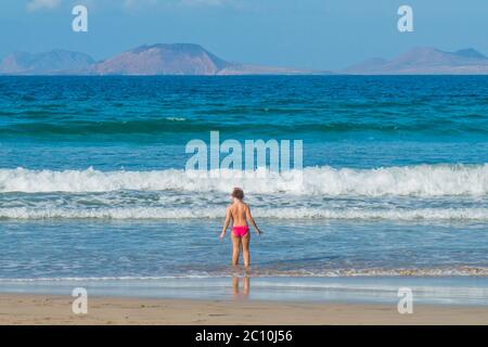 Famara Beach, beliebter Surfstrand an der Küste von Lanzarote. Kanarische Inseln. Spanien. Sanddünen und Menschen am Strand Stockfoto