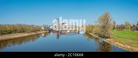 Panorama-Stadtbild von alten Eisenbahn Metall rostigen Brücke über Elbe in der Innenstadt von Magdeburg und Dom im Frühjahr, Deutschland Stockfoto