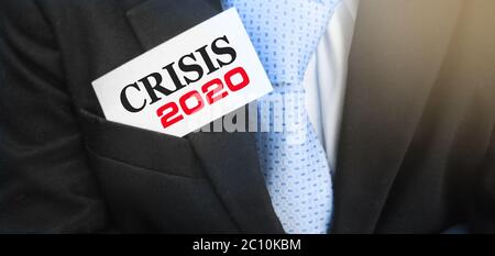 Krise 2020 auf einer Karte in der Tasche des Geschäftsmannes. Konzept der wirtschaftlichen Finanzkrise Stockfoto
