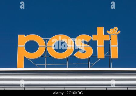 Die Hauptniederlassung der Posti Group beleuchtet Buchstaben vor dem klaren blauen Himmel in Postintaival 7, Helsinki, Finnland Stockfoto