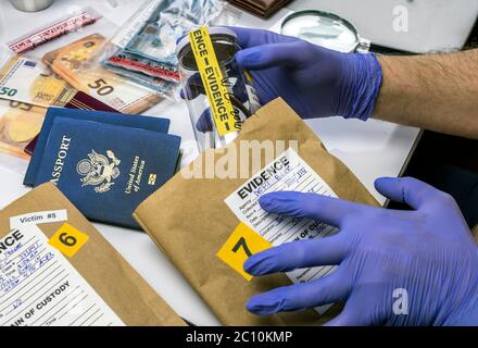 Experte Polizeioffizier Prüfung der amerikanischen Pass eines Beweis Tasche im Labor der Kriminologie, konzeptionelle Bild Stockfoto