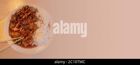 Banner mit asiatischem Fast-Food-Stil, gebratenes Huhn mit Gemüse, Reis und Holzchelchstäbchen mit Platz für Text Stockfoto