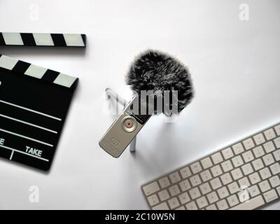 Nehmen Sie Audio im Inneren auf Zoom h1 Recorder mit toten Katze im Aufnahmestudio auf weißem Hintergrund bei natürlichem Tageslicht. Im Hintergrund werden Objekte wie Clapperboard und Tastatur angezeigt. Sie können dieses Foto in jedem Projekt verwenden, das mit Tonaufnahmen, Podcast, Tonstudio, Interview oder journalistischen Aktivitäten in Verbindung steht. Hochwertige Fotos Stockfoto