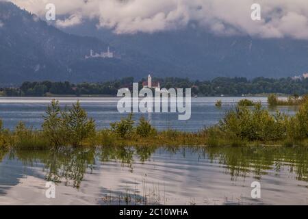 Blick über den Forggensee bei Füssen nach Schwangau und das Schloss Neuschwanstein im Hintergrund. Stockfoto