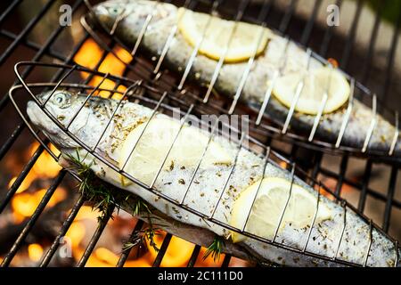 Köstliche Forelle mit Gewürzen braten auf einem Grill über dem Feuer Stockfoto