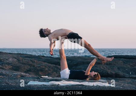 Paar Yoga-Übungen im Freien am Strand Stockfoto