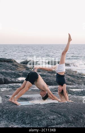 Paar Yoga-Übungen im Freien am Strand Stockfoto