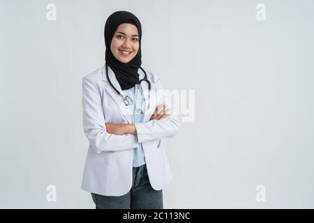 Ziemlich muslimisch jung lächelnd Arzt in weiß Kreuzende Arme auf Brust Stockfoto