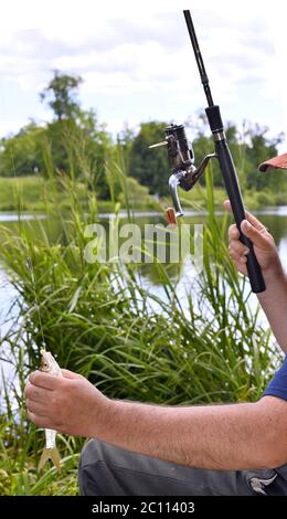Nahaufnahme der Kerl sitzt auf der Brücke und Angeln Stockfoto