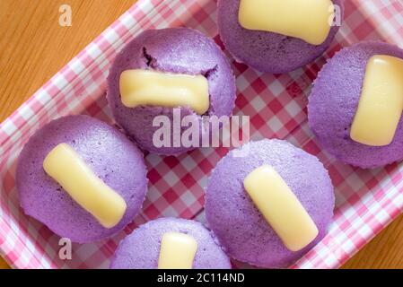 Ube Puto mit Käse.EIN philippinischer Reis Cupcake Muffin mit Rohr lila Yam Geschmack. Stockfoto