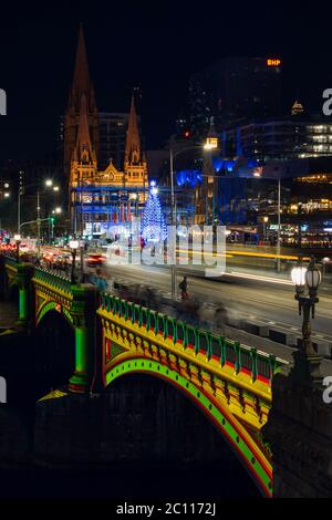 MELBOURNE, AUSTRALIEN - 8. Dezember 2019 - Langzeitbelichtung einer Weihnachtsprojektion auf einer belebten Princes Bridge in der Stadt Melbourne in Australien. Stockfoto