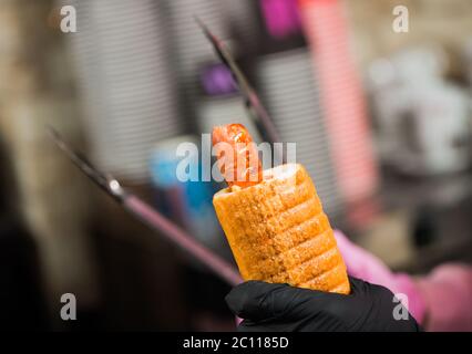 Barkeeper macht französisch Hot Dog mit Grill Wurst Stockfoto