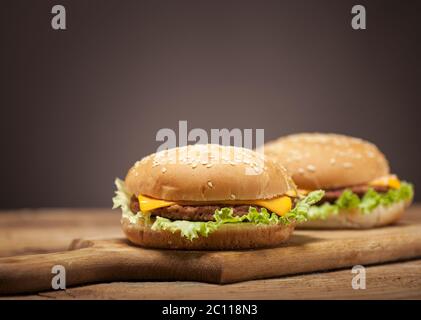 Frische Burger auf Holztisch Stockfoto