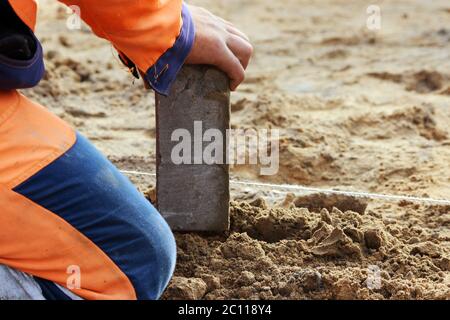 Verlegung von Pflasterplatten. Reparieren des Gehwegs Stockfoto