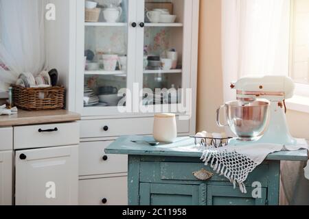 Leere Küche mit altem Tisch und Mixer und Eiern zum Backen von Kuchen. Stockfoto