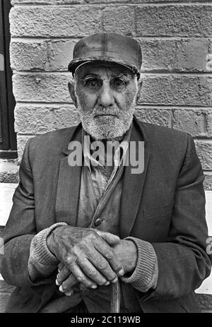 Porträt eines älteren hispanischen Mannes mit Bart auf einer Bank mit einem Stock sitzend, in Santa Fe, New Mexico, um 1973. Stockfoto