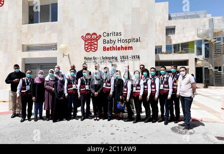 (200613) -- BETHLEHEM, 13. Juni 2020 (Xinhua) -- Mitglieder des chinesischen Ärzteteams und Ärzte des Caritas Baby Hospital posieren für ein Gruppenfoto vor dem Krankenhaus in der Stadt Bethlehem im Westjordanland, 13. Juni 2020. Ein chinesisches medizinisches Team kam am 10. Juni nach Palästina, um den Palästinensern beim Kampf gegen COVID-19 zu helfen. Das 10-köpfige Team, das von Chinas nationaler Gesundheitskommission geschickt wurde, besteht aus Experten, die auf verschiedenen medizinischen Gebieten spezialisiert sind, einschließlich Infektionskrankheiten, Virusuntersuchung und Gesundheitsmanagement, so Guo Wei, Direktor des Büros der Volksrepublik China nach Pa Stockfoto