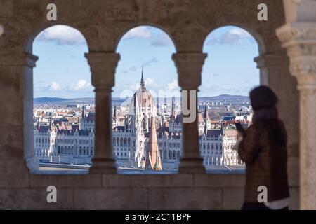 Ungarisches Parlament Blick durch Korridor Ansicht auf Fischerbastei mit verschwommenen Touristen Figur in Budapest Stockfoto