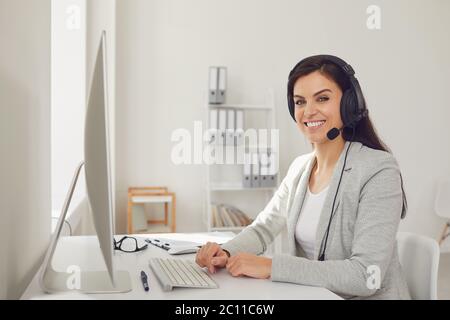 Callcenter-Telefonistin Frau im Headset sitzt an einem Computer am Arbeitsplatz. Konzept Helpdesk Online-Shop Stockfoto