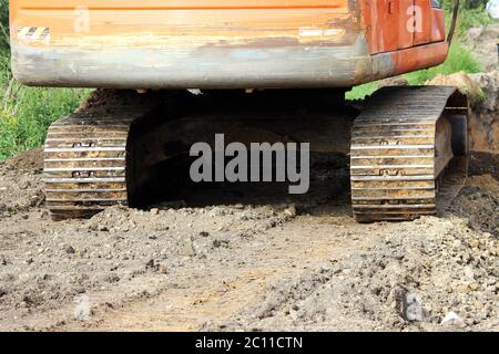 Raupen von schweren Baumaschinen Raupenbagger auf dem Gelände für die Erweiterung der Straße. Stockfoto