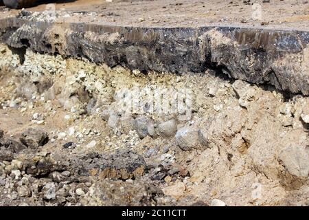 Schichten im Boden, erzählt die Geschichte der Konstruktion der Straße in Gatchina. Sichtbare Schicht Steinschutt Alter 250 Jahre - t Stockfoto