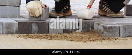 Verlegung von Pflasterplatten auf dem Stadtplatz, Reparatur Bürgersteig. Stockfoto