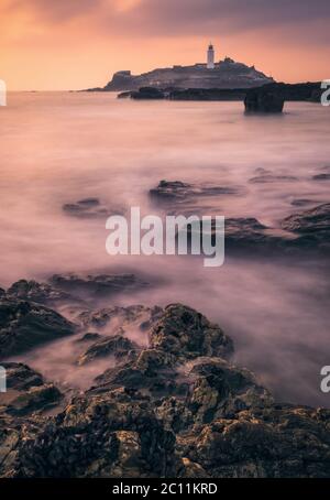 Ein wunderschöner Sonnenuntergang am Godrevy Point Leuchtturm, an der nordatlantischen Küste von Cornwall, England, Großbritannien Stockfoto