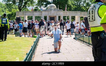 Brighton UK 13. Juni 2020 - einer der Männer, die angeblich Teil der rechten Gruppen sein sollen, geht auf die Knie am Kriegsdenkmal, während am Kriegsdenkmal Tausende an der Anti-Rassismus-Protestkundgebung von Black Lives Matter durch Brighton teilnehmen. Es gab Proteste in ganz Amerika, Großbritannien und anderen Ländern seit dem Tod von George Floyd, während er von der Polizei in Minneapolis am 25. Mai verhaftet : Credit Simon Dack / Alamy Live News Stockfoto