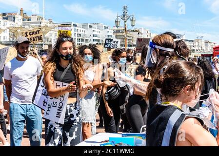 Brighton, East Sussex, Großbritannien. 13. Juni 2020.Protestierende, die Handgel benutzen und Gesichtsmasken am Black Lives Matter march am Brighton Palace Pier erhalten. Brighton, East Sussex, Großbritannien. ©Julia Claxton Kredit: Julia Claxton/Alamy Live Nachrichten Stockfoto