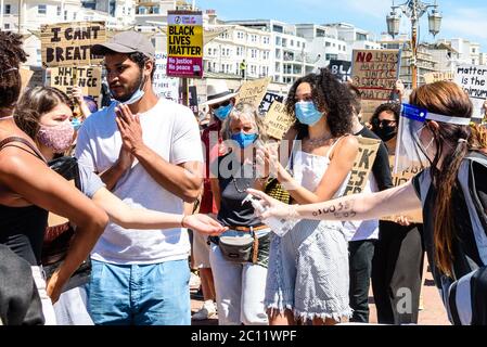 Brighton, East Sussex, Großbritannien. 13. Juni 2020.Protestierende, die Handgel benutzen und Gesichtsmasken am Black Lives Matter march am Brighton Palace Pier erhalten. Brighton, East Sussex, Großbritannien. ©Julia Claxton Kredit: Julia Claxton/Alamy Live Nachrichten Stockfoto
