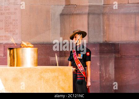 Ein Armeesoldat, der unter dem Kriegsdenkmal des India Gate steht, trägt die Uniform auf der Abendzeremonie, die das Eigentum der indischen Regierung schützt. Stockfoto