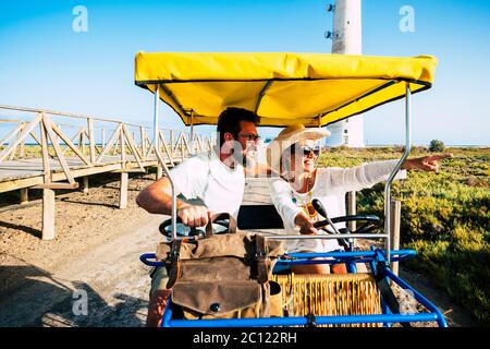 Touristen und Tourismus Menschen Konzept mit fröhlichen und glücklich erwachsenen Paar auf einem surrey Fahrrad genießen die Outdoor-Freizeitaktivitäten im Urlaub Sommer holi Stockfoto