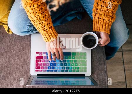 Vertikale Ansicht Erwachsene Frau Hände arbeiten und schreiben auf einem farbigen Laptop-Tastatur, während einen Kaffee trinken - Job und Arbeit Menschen Konzept mit Technologie Stockfoto